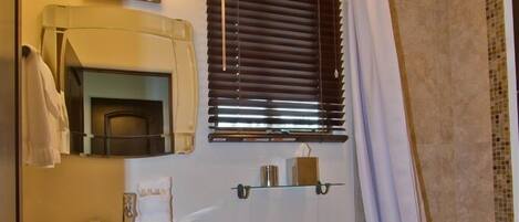 A bathroom with a toilet, sink, and shower area.