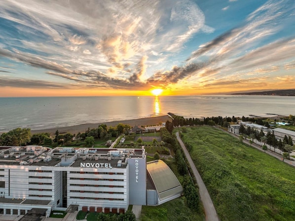 Un hotel de diseño moderno, situado cerca de una playa con vistas al atardecer.