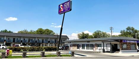 A Stay Express Inn with a prominent sign, a parking lot, and a building with a covered entrance.