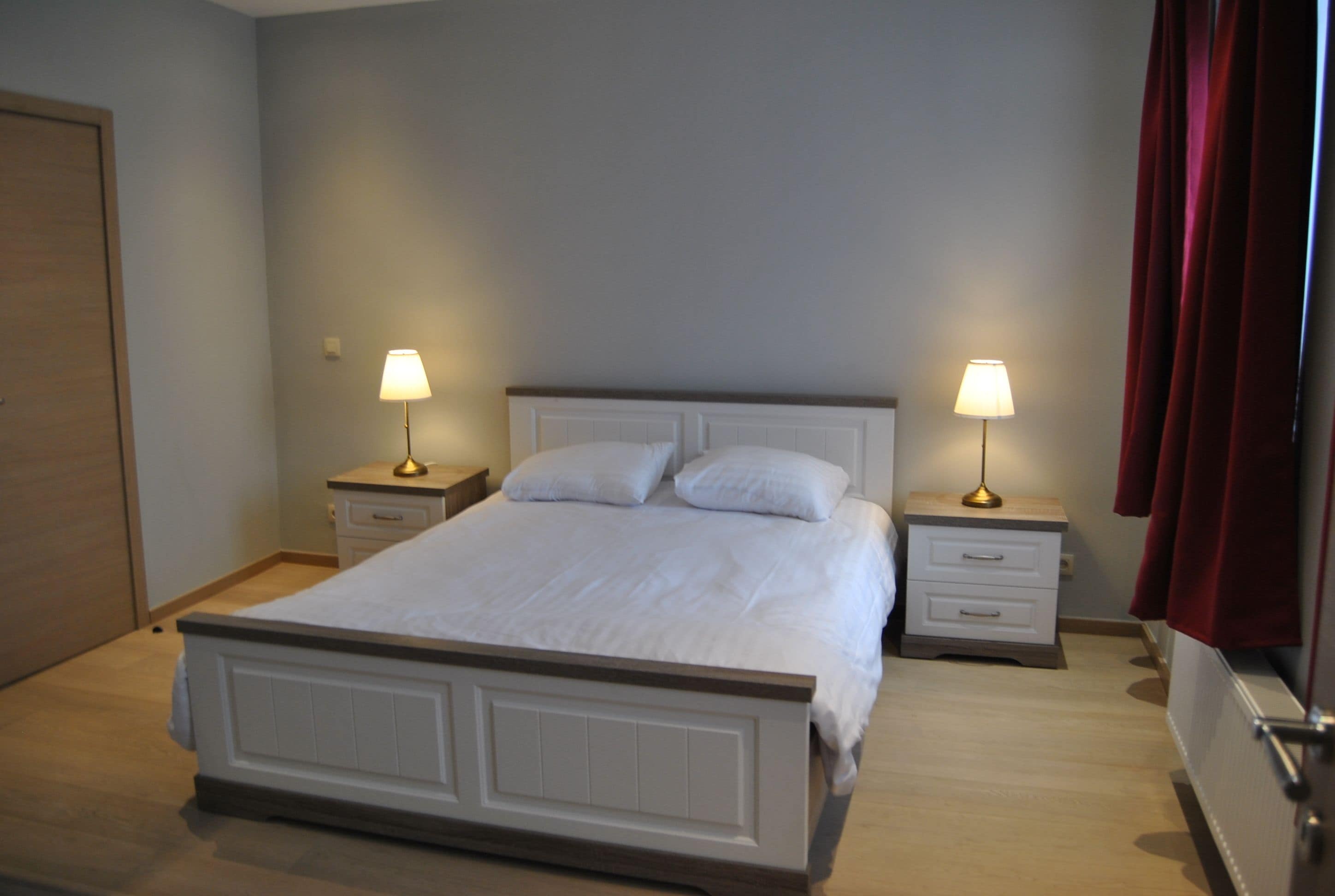 Una camera da letto con un letto, due comodini e lampade.