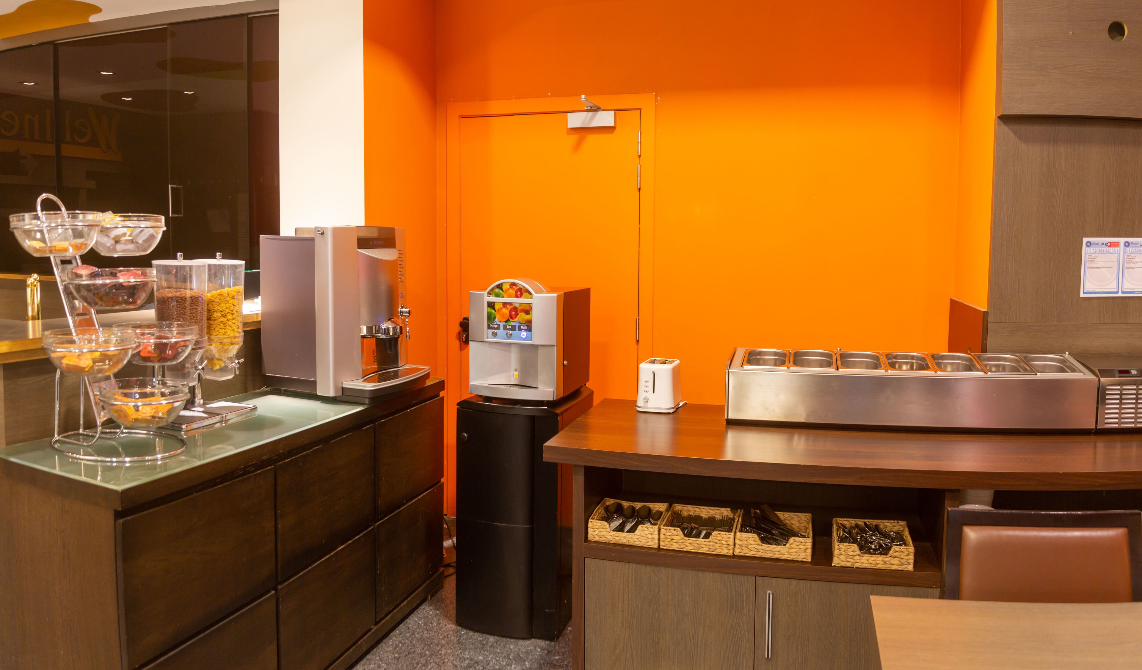 Een ontbijtbuffet met een koffieapparaat, theedispenser en een broodrooster.