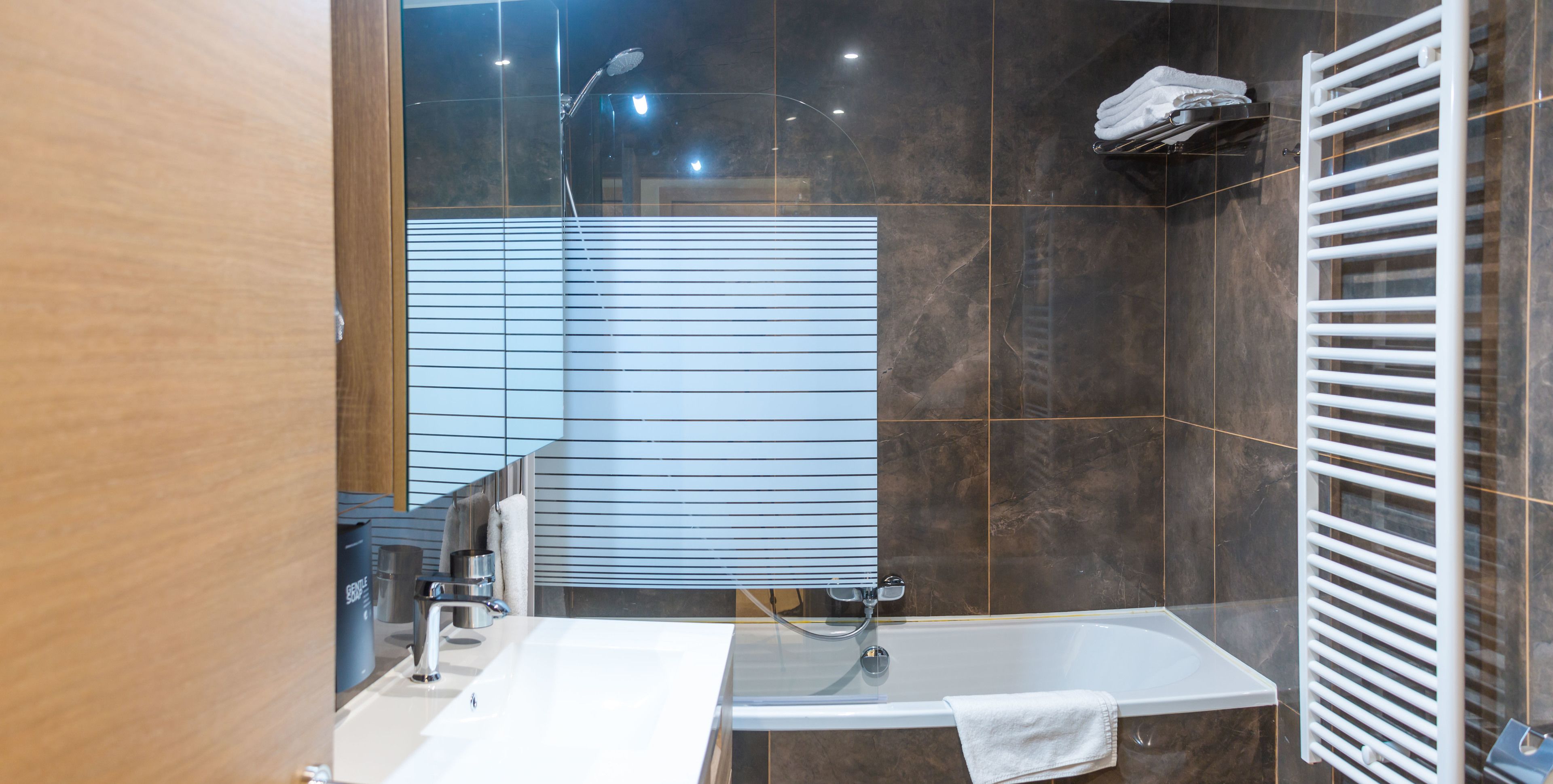 Ein modernes Badezimmer mit Badewanne, Waschbecken und Dusche.