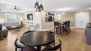 A spacious living area with a round dining table, a sofa, and a ceiling fan. - Love Farms Lodge (West Dennis)