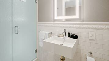 A bathroom with a white sink, mirror, and towel rack.