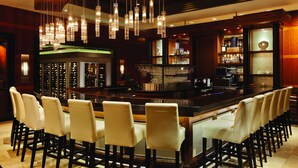 A bar area with multiple seating options, a wine rack, and a bar counter. - Caesars Windsor Hotel & Casino - A Caesars Rewards Destination (Windsor)