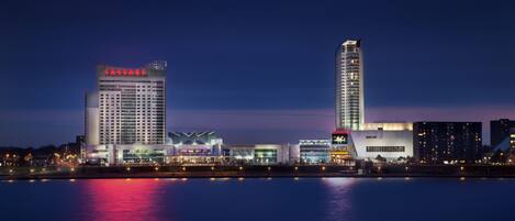 A city skyline with modern buildings, including a hotel with a prominent sign.