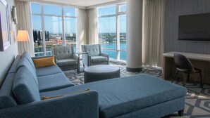 A modern hotel room with a large sofa, armchairs, a small table, and a TV mounted on the wall. - Caesars Windsor Hotel & Casino - A Caesars Rewards Destination (Windsor)