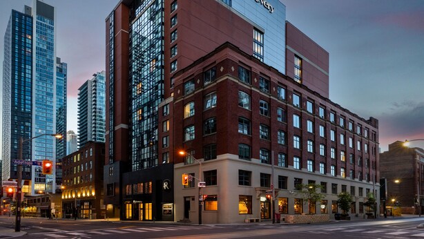 A hotel with a modern facade, featuring a prominent 'Reverie' sign on the upper level. - Revery Toronto Downtown, Curio Collection by Hilton (Toronto)