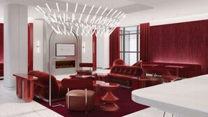 A modern interior with red furniture, a white ceiling, and a large chandelier. - Revery Toronto Downtown, Curio Collection by Hilton (Toronto)