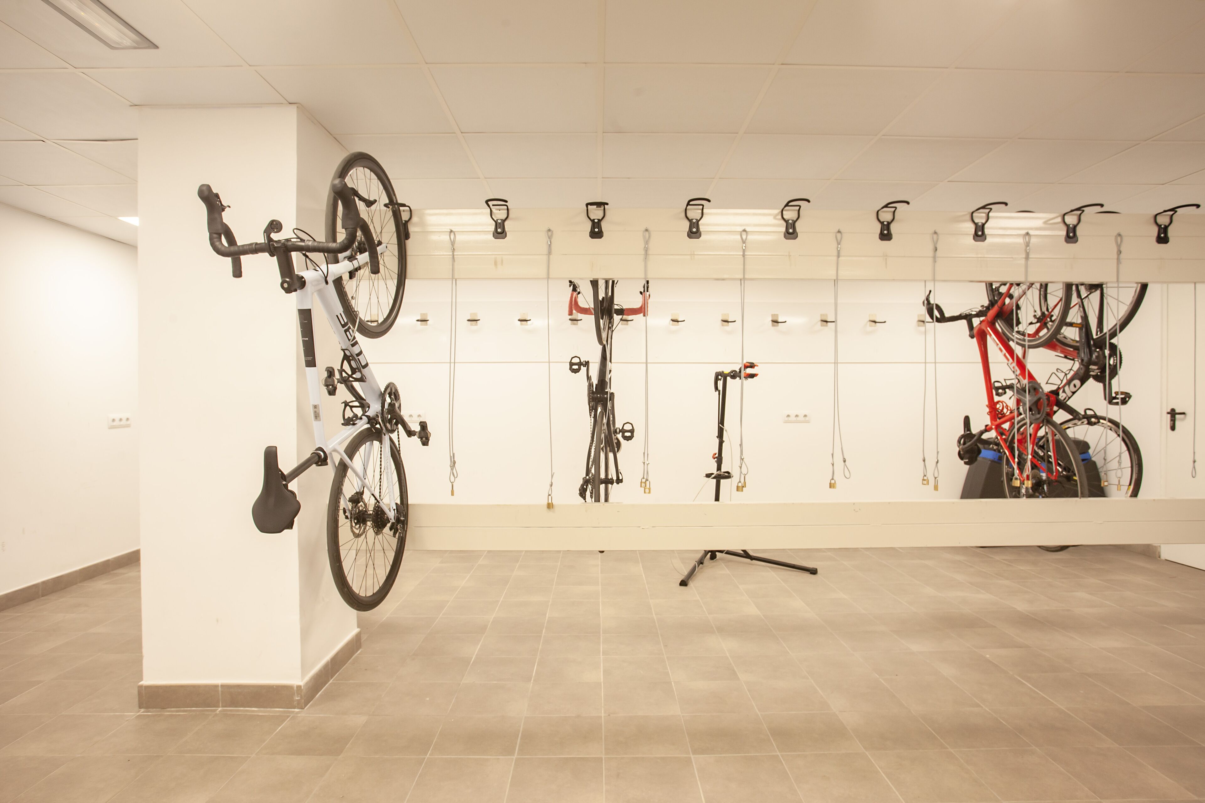 Uma área de armazenamento para bicicletas com várias bicicletas fixadas em ganchos.