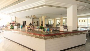 A spacious bar area with a marble countertop, multiple liquor bottles, and a modern ceiling design. - Maracaibo (Santa Margalida)