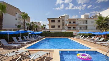 Una piscina al aire libre, sombrillas, tumbonas