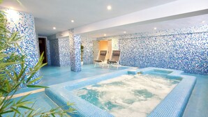 Un espace spa comprenant un jacuzzi, des chaises longues et des murs carrelés.