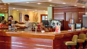 A bar area with a counter, bar stools, and a variety of bottles and glasses. - Ilusion Markus & Spa (Santa Margalida)