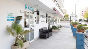 A hotel named RAXA with a restaurant named TABURO. There are outdoor seating areas with potted plants and a clear view of the street. - Raxa (Palma de Mallorca)