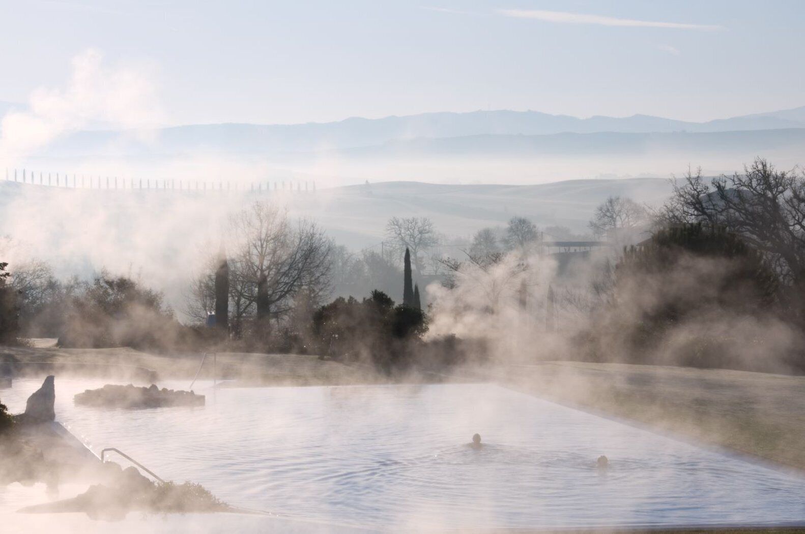 A steam bath with a view of distant mountains and a fence.