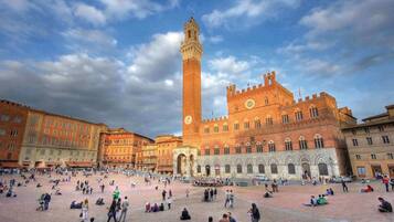 A historic square with a prominent tower and a large open space for gatherings.