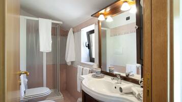 Un bany amb dutxa, vàter, rentapèls i mirall.