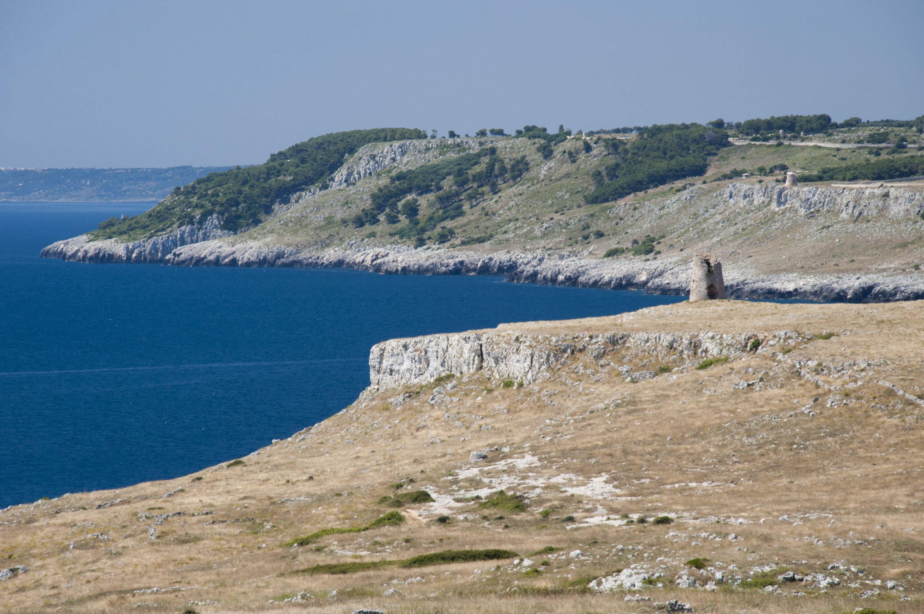 Eine Küstenlandschaft mit schroffen Klippen und freiem Blick auf das Meer.