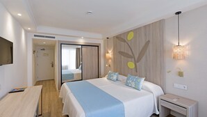 Una habitación de hotel moderna con una cama grande, mesitas de noche, un escritorio y un armario.