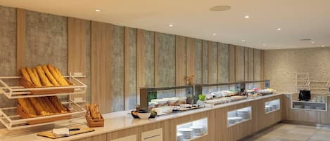 A modern buffet setup with multiple food stations, wooden paneling on the walls, and a clean, tiled floor.