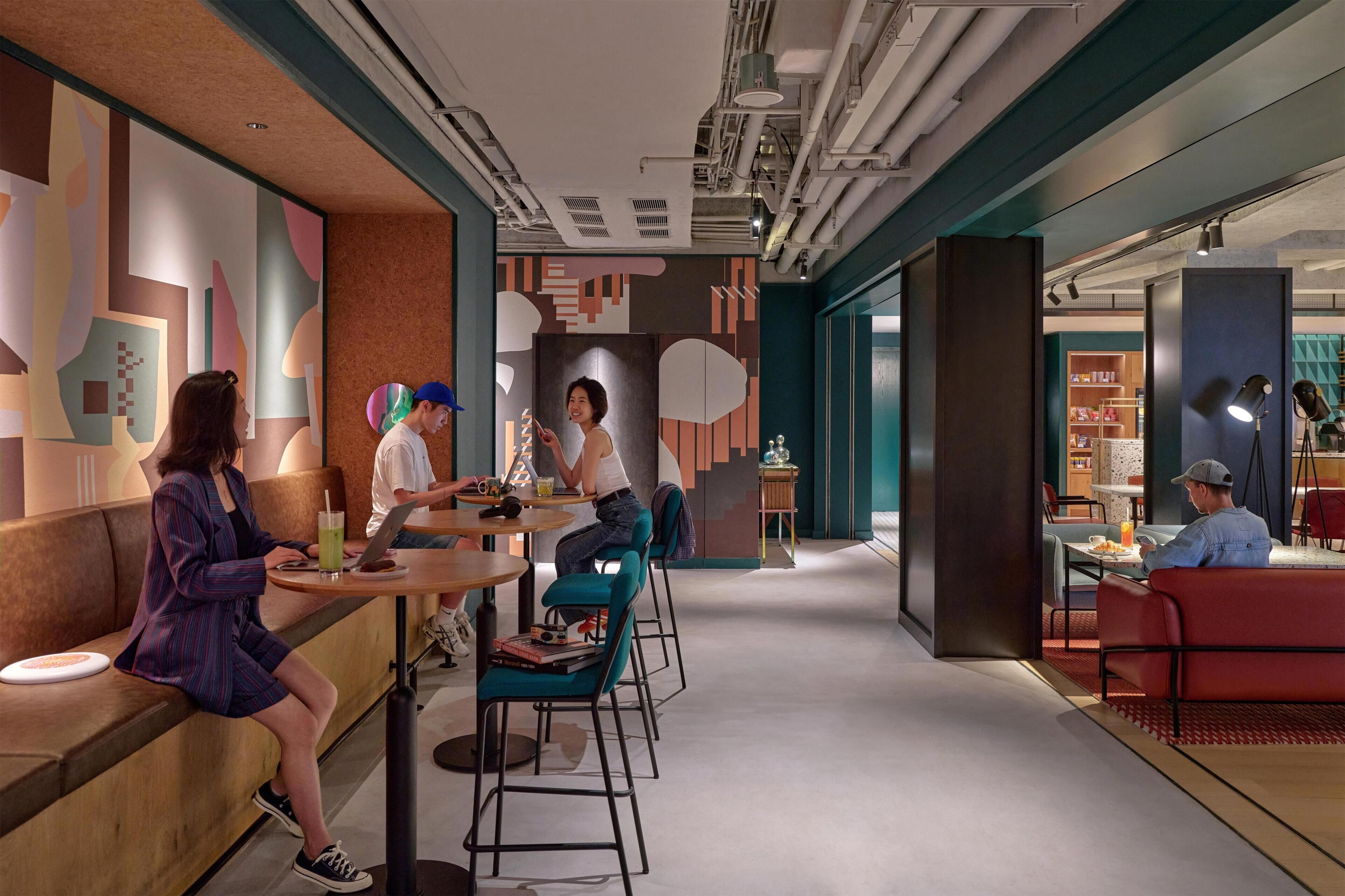 A modern interior with seating areas, tables, and a visible kitchen area.