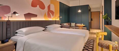 Una habitación de hotel moderna con una cama grande, mesitas de noche, un escritorio y una silla.