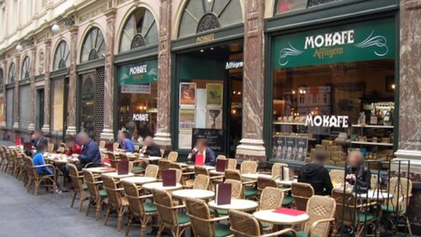 An outdoor café with wicker tables and chairs, a stone building facade, and a sign for 'MOKAFE'. - B-aparthotel Grand Place (Brussels)