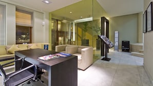 A modern reception area with a reception desk, seating area, and a glass partition. - B-aparthotel Grand Place (Brussels)