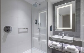 Bañera con ducha, artículos de tocador de diseñador, secador de pelo