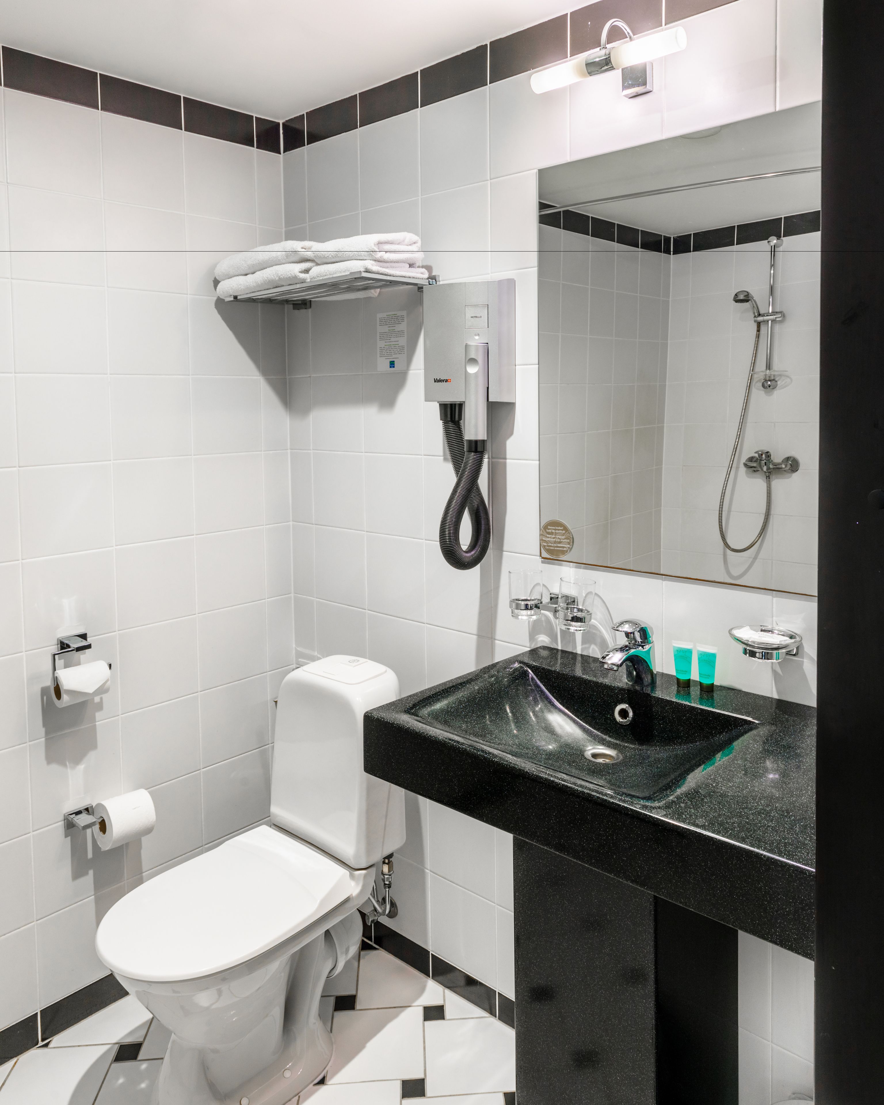 A modern bathroom with a toilet, sink, and shower.