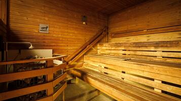Uma sauna com bancos de madeira e um banco com porta-toalhas.