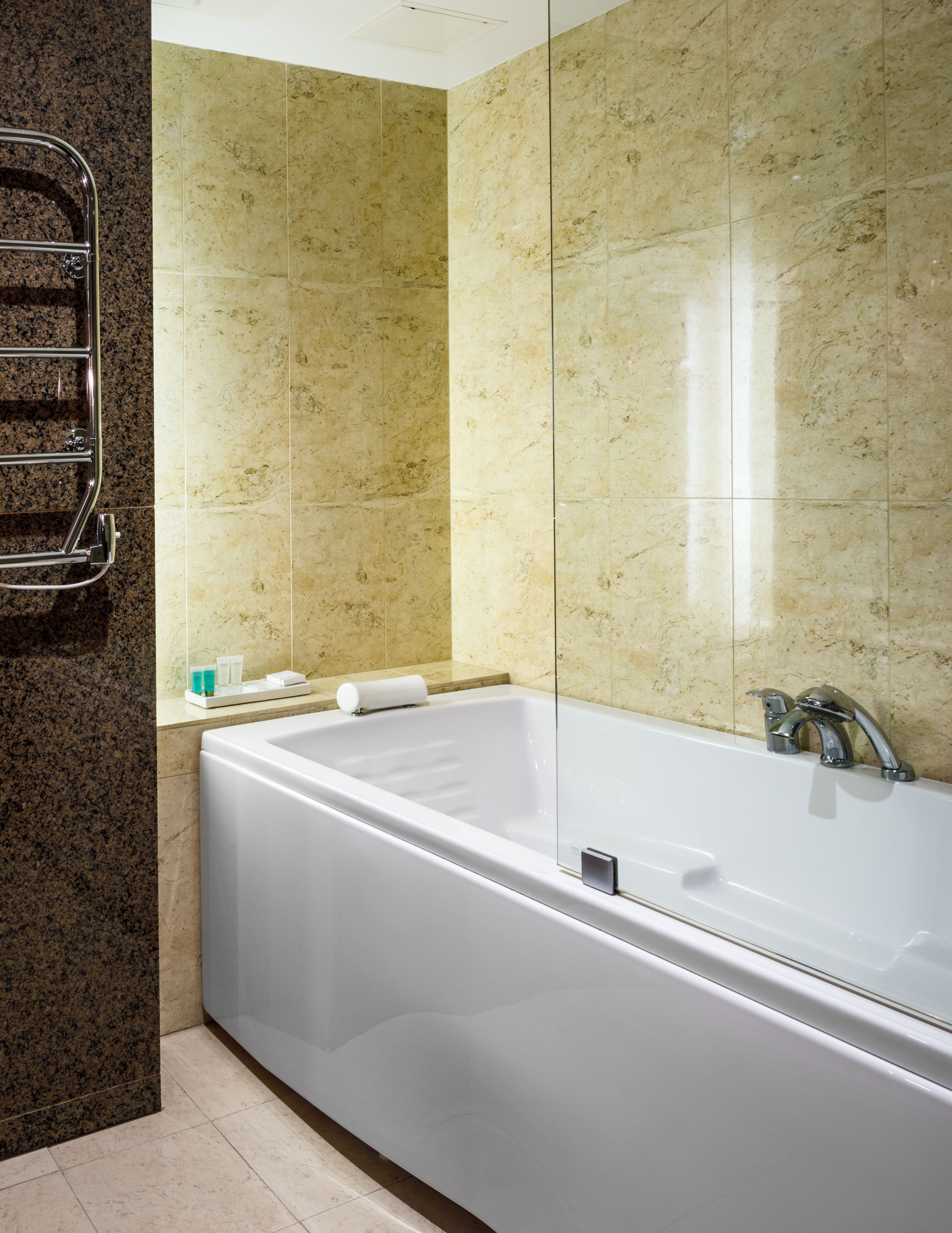Un baño moderno con una bañera grande, un box de ducha de vidrio y una encimera de granito.