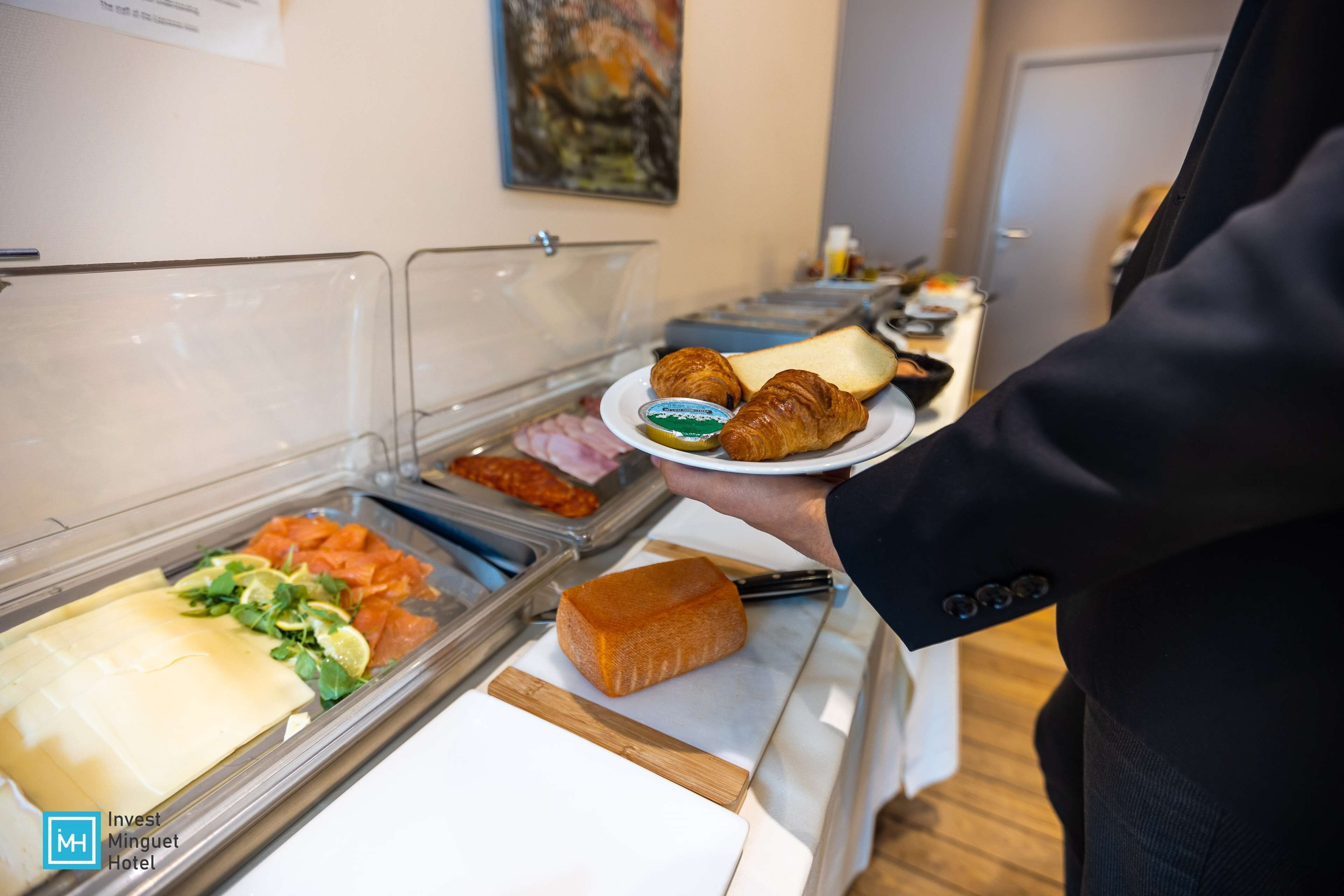 A buffet with various food items including cheese, bread, and pastries.