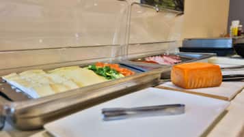 Un bufé con diversos alimentos, incluyendo queso, verduras y carnes.