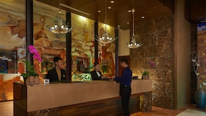 A hotel reception area with a marble counter, two receptionists, and a customer. - GRAND NEW CENTURY HOTEL Binhai Tianjin (Tianjin)