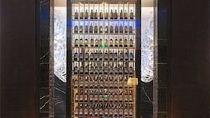 A lobby with a wine rack, two sofas, and a patterned carpet. - GRAND NEW CENTURY HOTEL Binhai Tianjin (Tianjin)