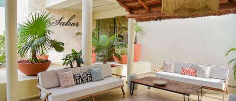 Un espace extérieur moderne aménagé avec deux canapés, une table basse et des plantes en pot.
