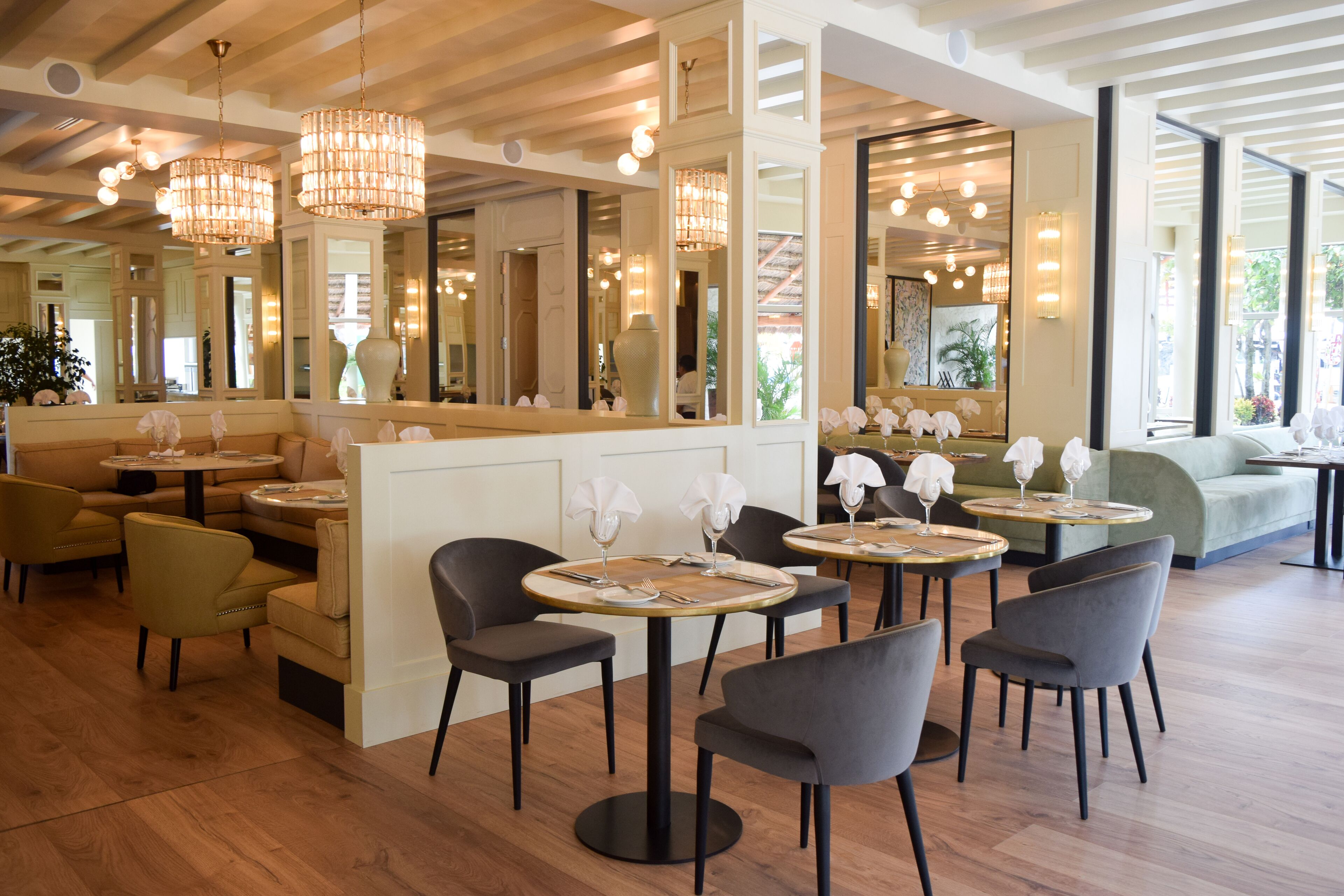 Een restaurant met ronde tafels, stoelen en kroonluchters.