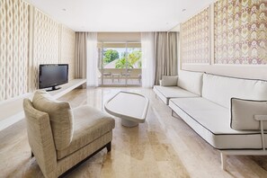 A modern living room with a sofa, armchair, and a flat-screen TV on a stand.