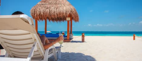 On the beach, white sand, sun loungers, beach umbrellas