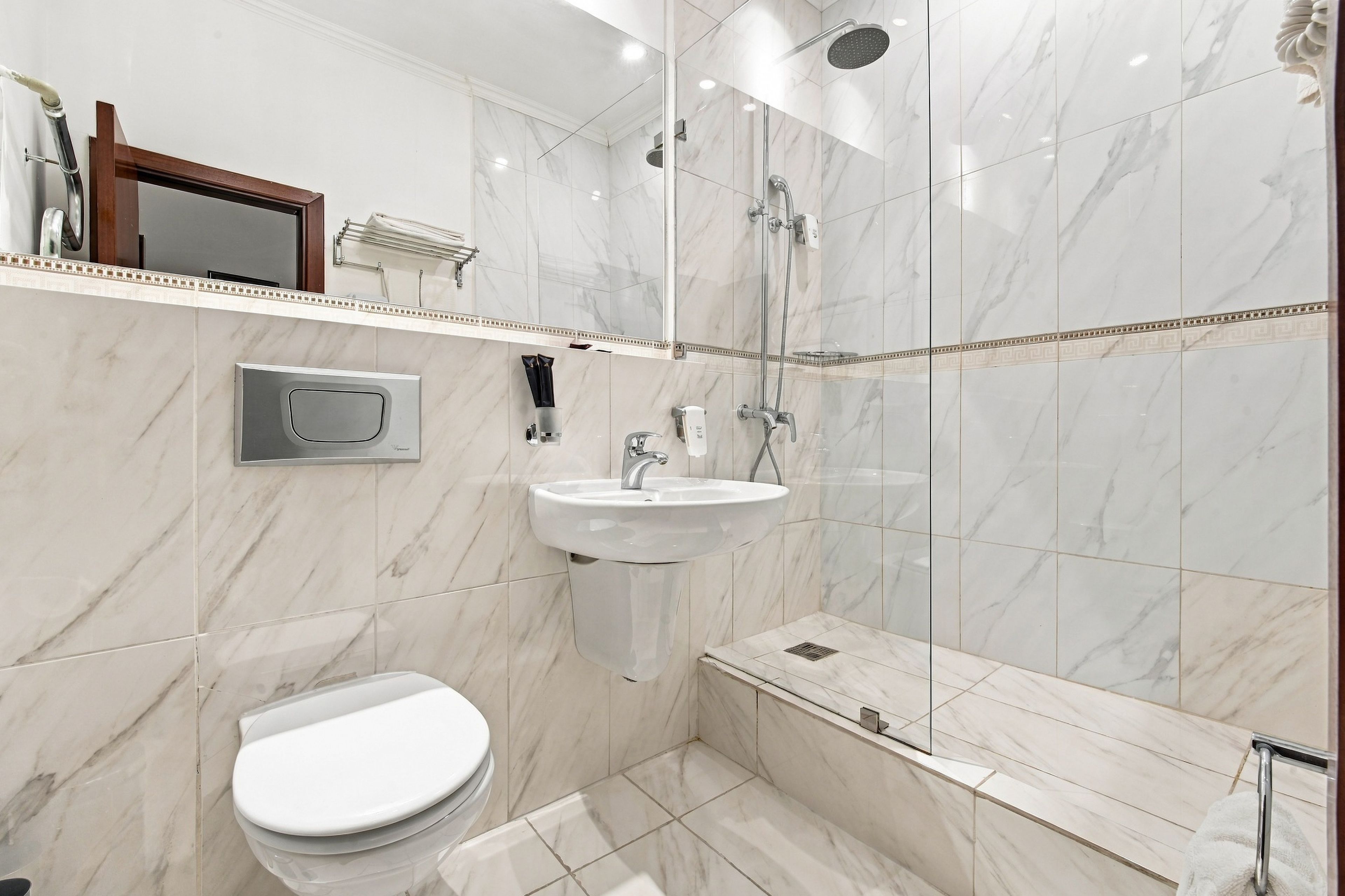 A modern bathroom with a toilet, sink, and shower.