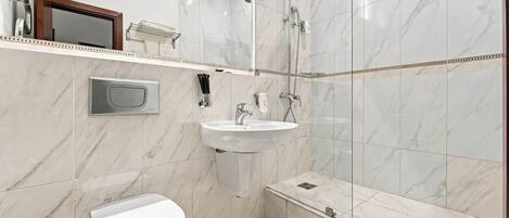 A modern bathroom with a toilet, sink, and shower.