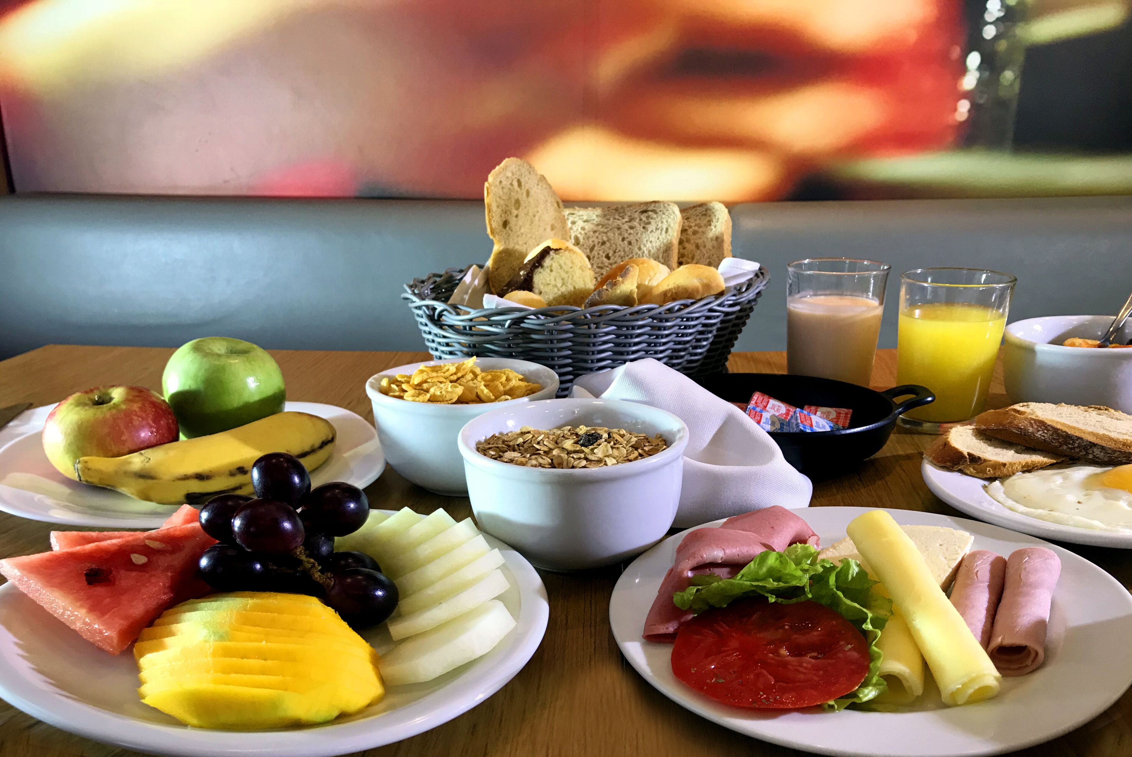 A breakfast buffet with various fruits, bread, and beverages.