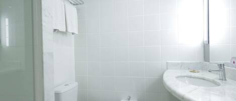 Un baño con inodoro, lavamanos y espejo.