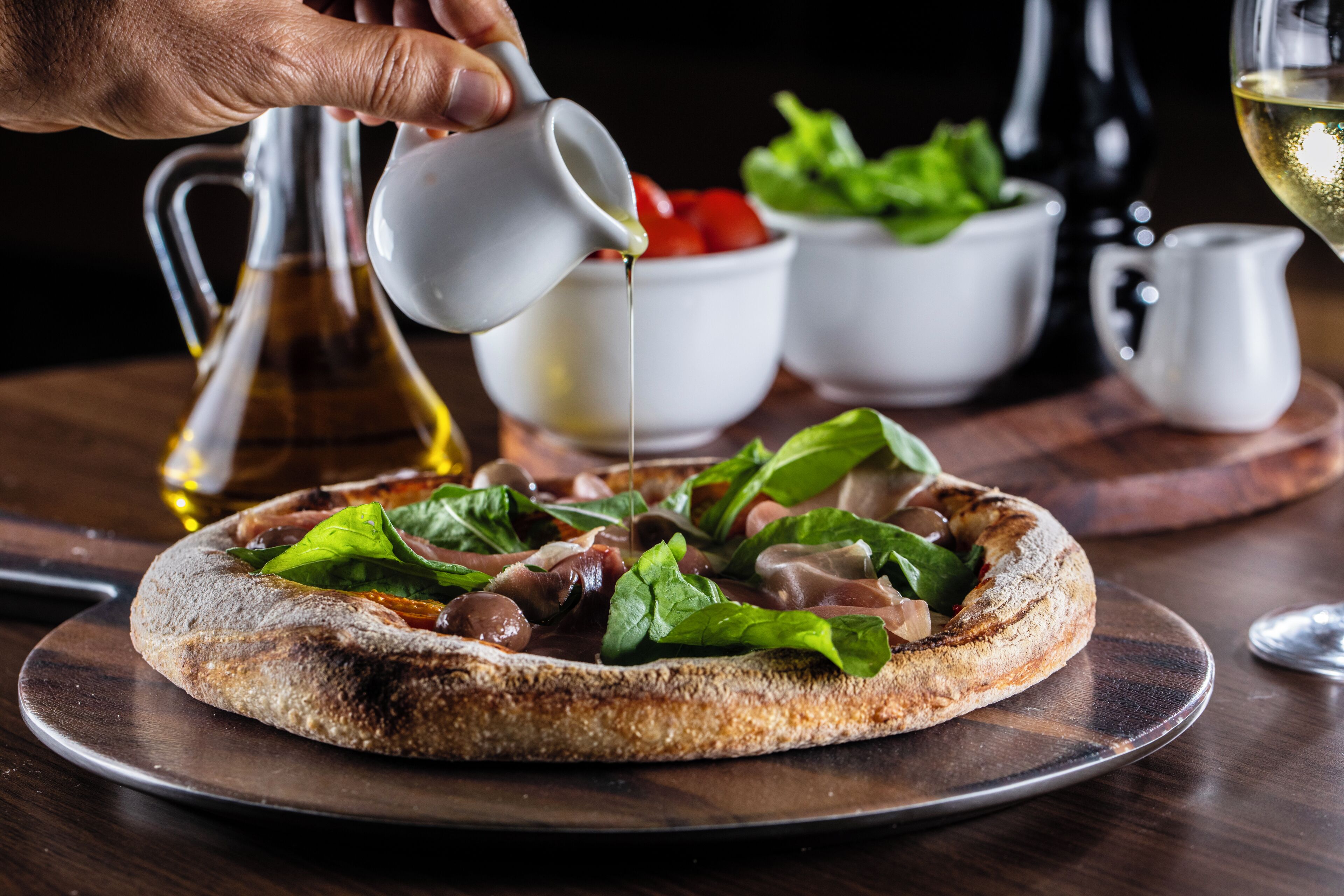Une pizza garnie, servie sur une planche en bois.