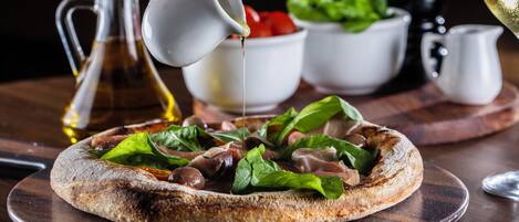 Une pizza garnie, servie sur une planche en bois.