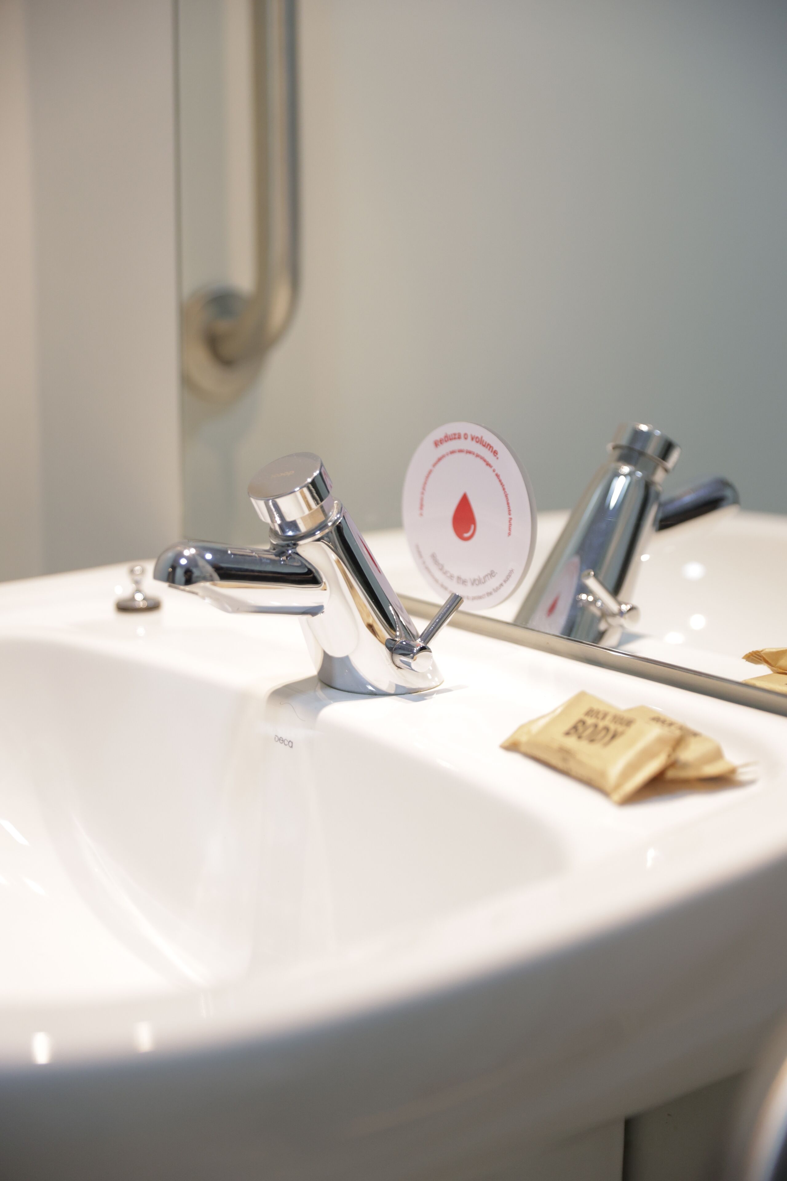 A bathroom sink with a mirror, a faucet, and a soap dispenser.