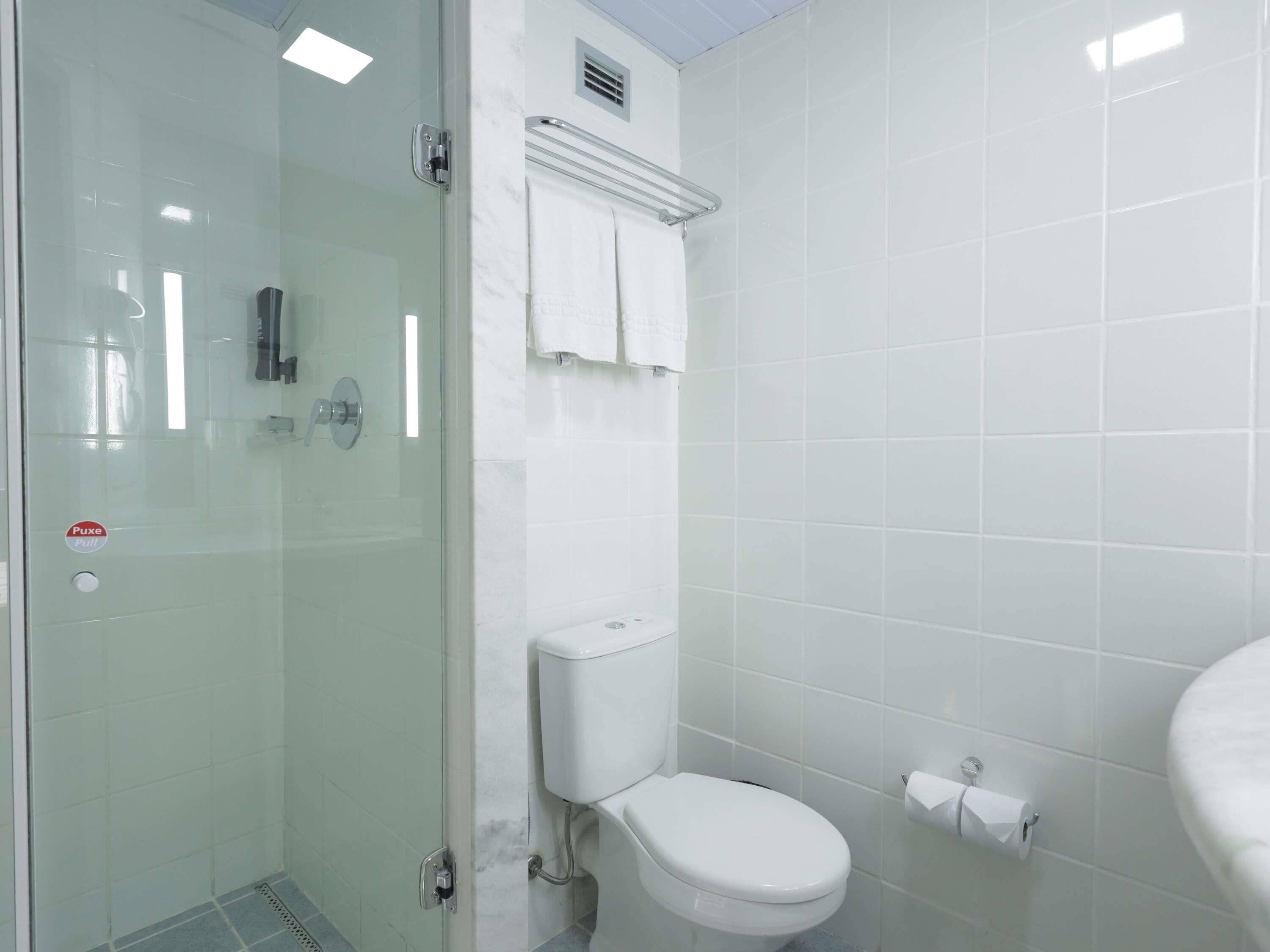 Ein Badezimmer mit einer Duschkabine, einer Toilette und einem Waschbecken.