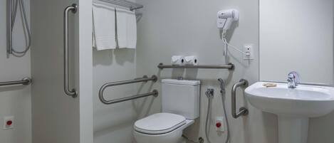 A bathroom with a toilet, bidet, hand dryer, and a sink.